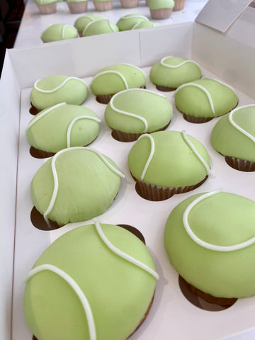 Cupcakes decorated to look like tennis balls in a box