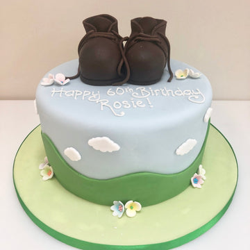cake with walking boots made from icing on top