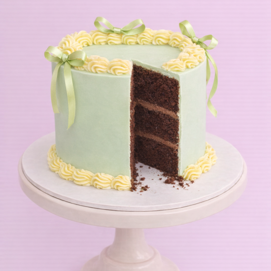 pale green and yellow easter spring themed ribbon cake with piped icing
